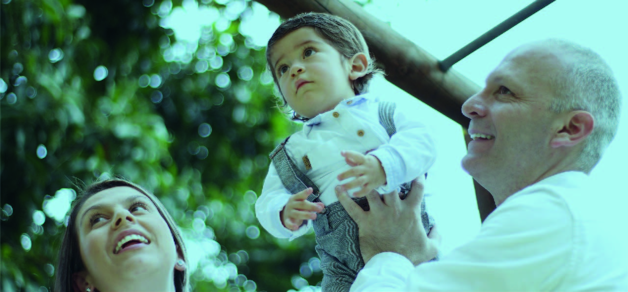 Familia sonriendo y disfrutando de un día soleado, representando la tranquilidad de tener una buena cobertura de salud.